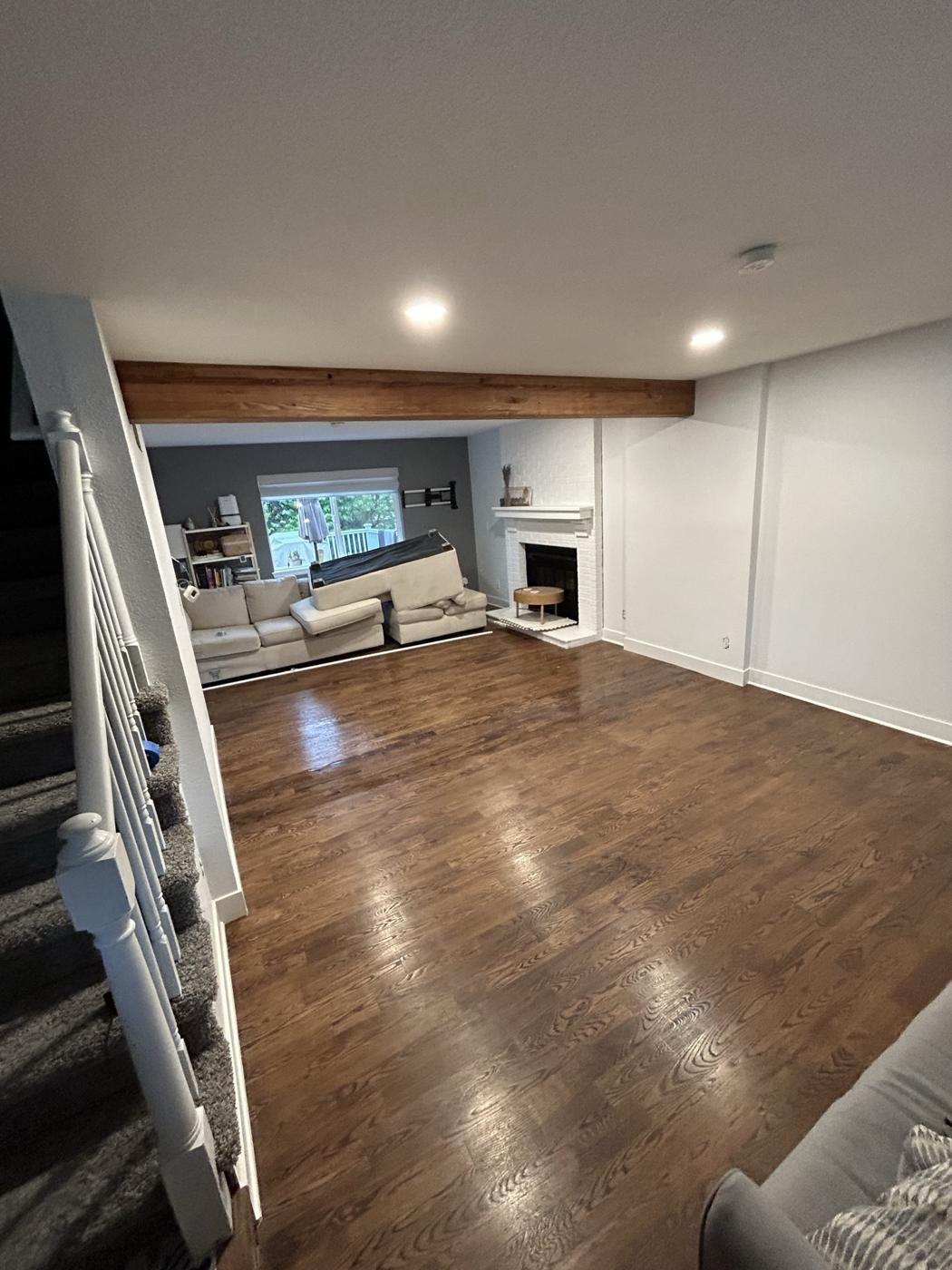 Open basement living room with a new beam overhead