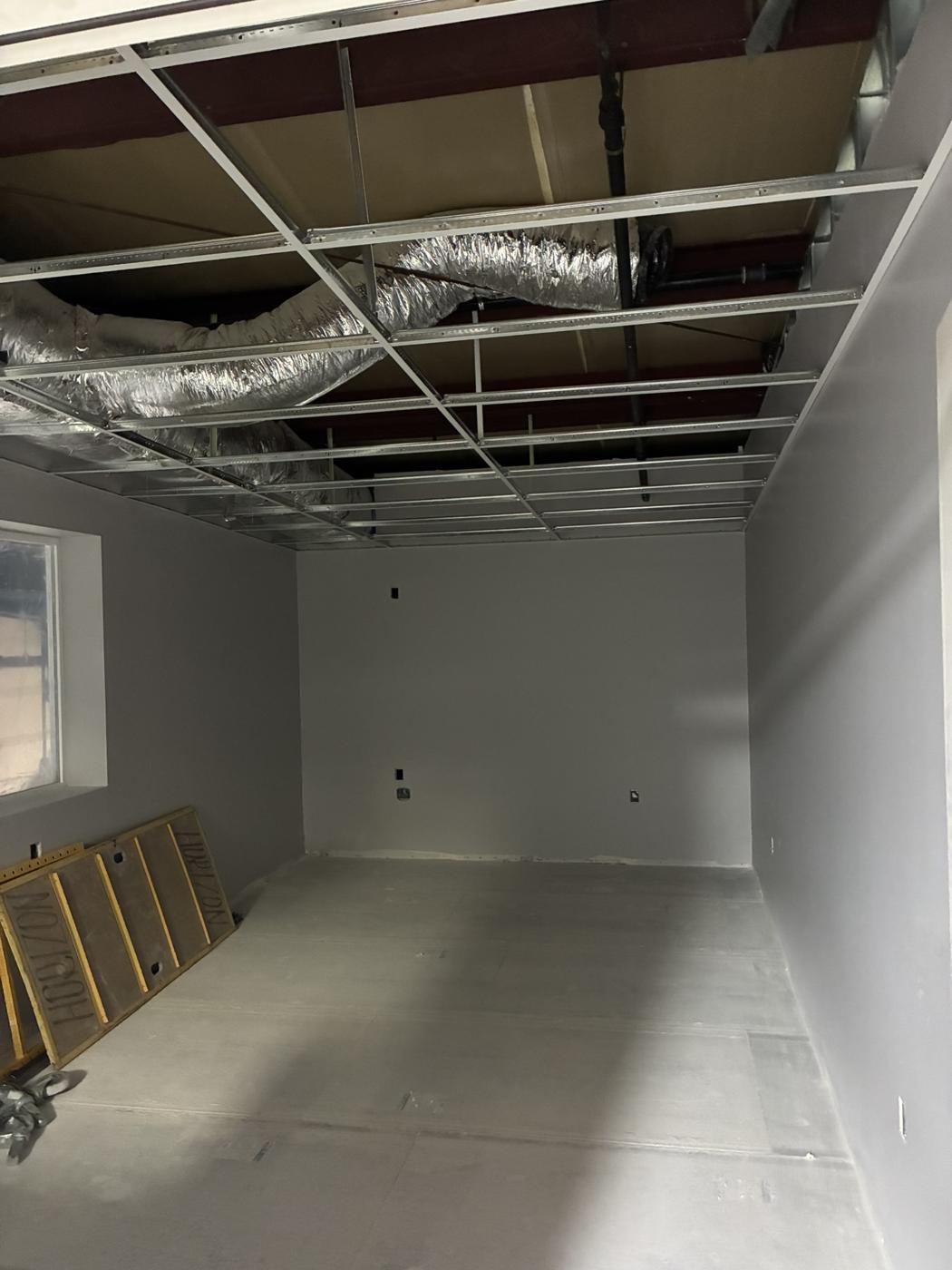 Empty unfinished shell with open ceiling grid before the build-out