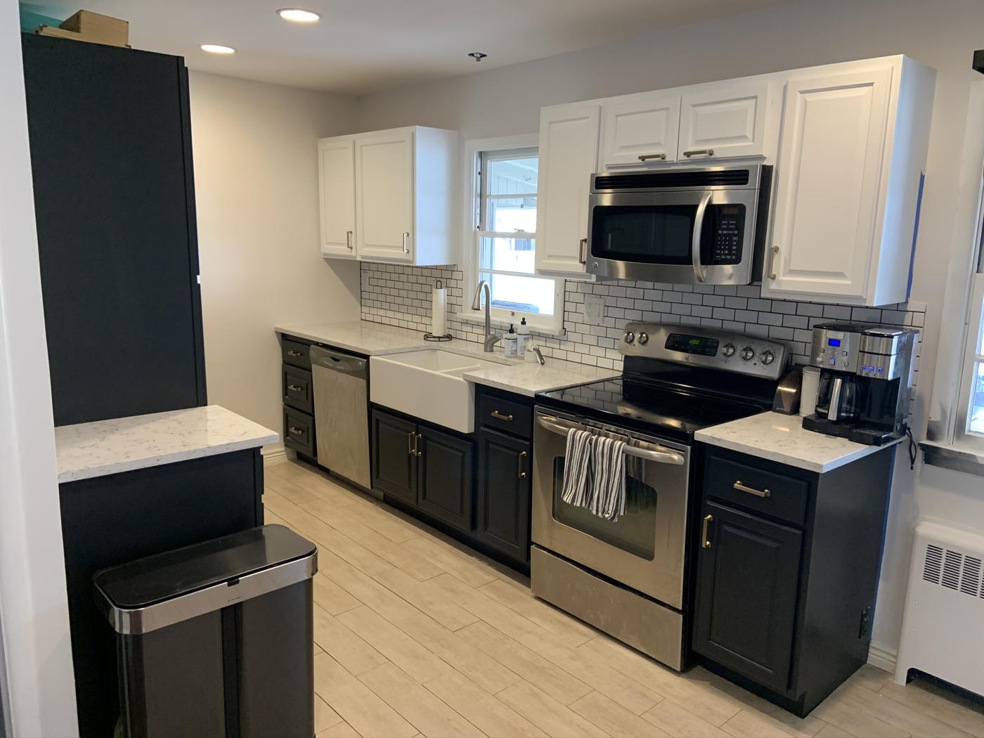 Remodeled kitchen with white cabinets and stainless appliances